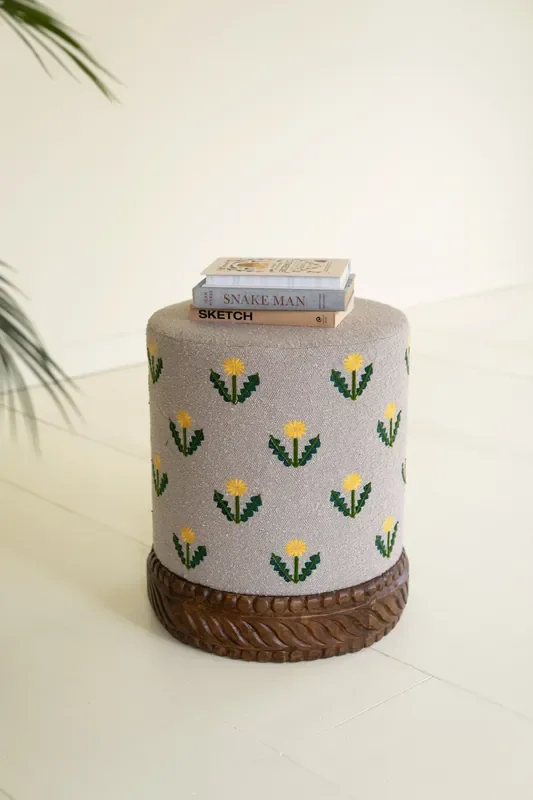 Grey Upholstered Ottoman with Embroidered Detail and Carved Wood Base